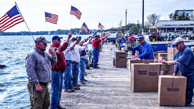 group of fishermen on Vermilion pier waving small American flags while reeling in fish
