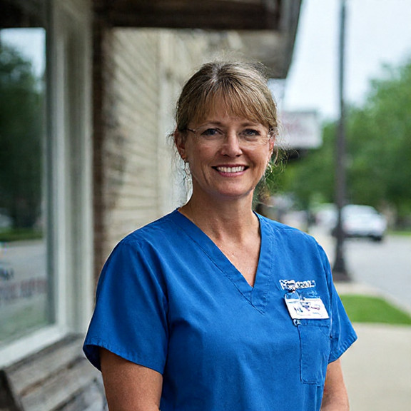 nurse in scrubs wearing a ‘Vermilion Patriots’ pin outside the local clinic